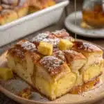 Plated Hawaiian Roll French Toast with powdered sugar and syrup drizzle