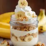 Banana pudding jar with whipped cream, vanilla wafers, and fresh banana slices