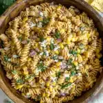 Creamy Elote pasta salad with roasted corn, cotija, and cilantro in a wooden bowl