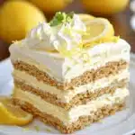 Tall layered lemon refrigerator cake with lemon slices and zest on top