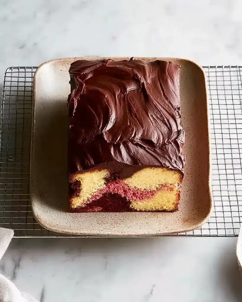 Sliced Best Neapolitan Marble Cake with chocolate, vanilla, and strawberry swirls on a ceramic plate—each slice showing off that perfect tri-color marbling.