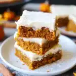 Pumpkin squares with cream cheese frosting and cinnamon dusting