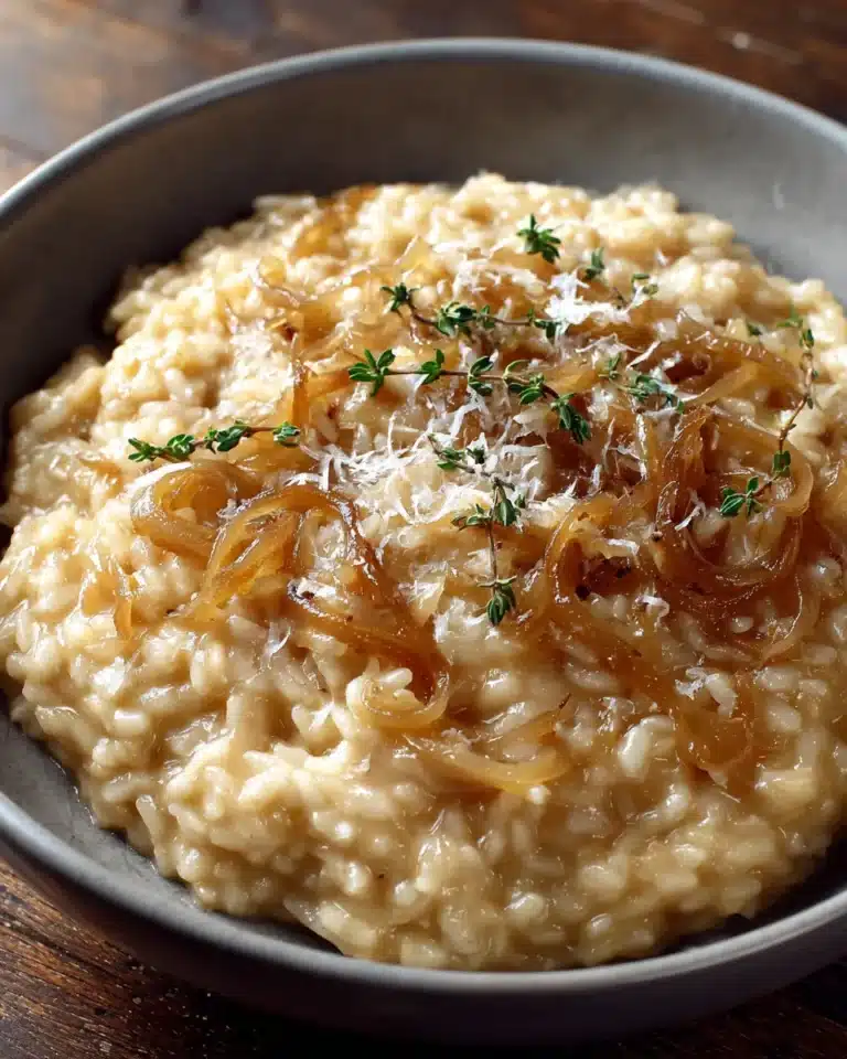 Creamy caramelized onion risotto topped with golden onions and thyme