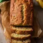 Homemade banana zucchini bread with golden crust and moist, green-flecked slices