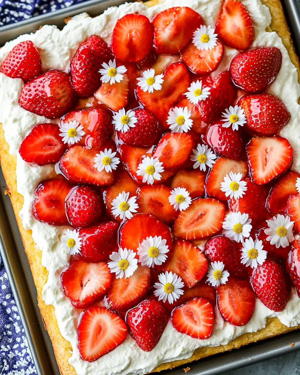 Decorated strawberry shortcake with flower garnish on sheet pan