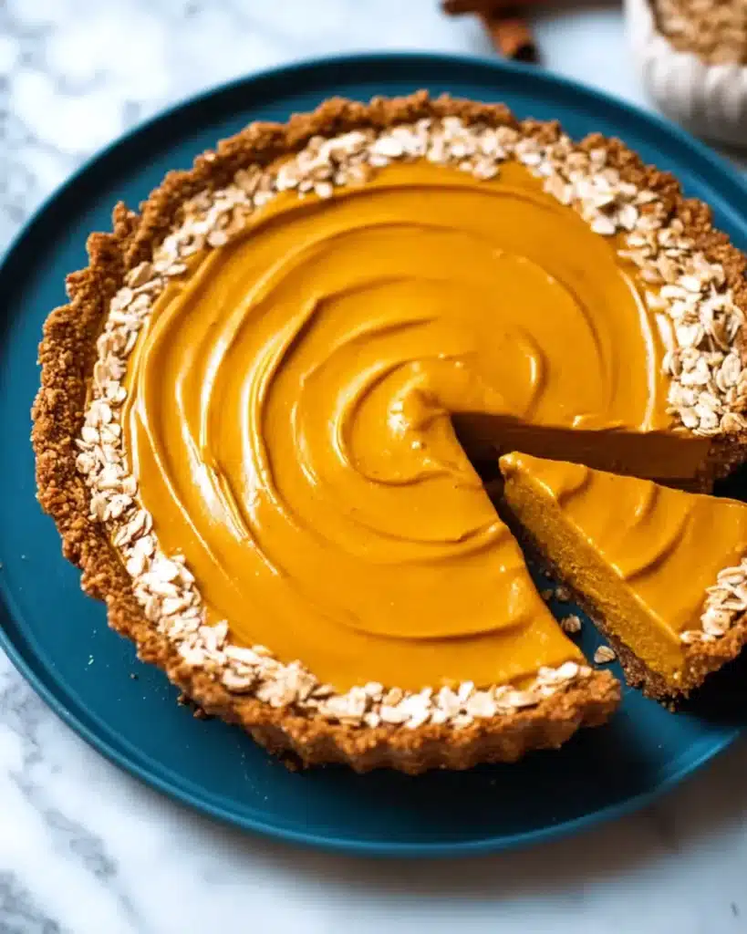 Vegan pumpkin pie slice with granola crust and coconut whipped cream
