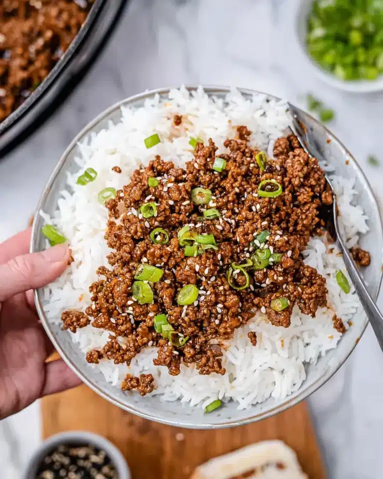 Ground beef and rice topped with sesame seeds and green onions.