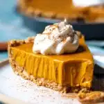 Vegan pumpkin pie with oat-topped crust and slice cut out