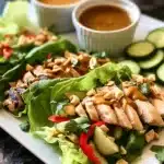 Grilled chicken Thai salad wraps with peanut sauce, cucumber, and fresh herbs.