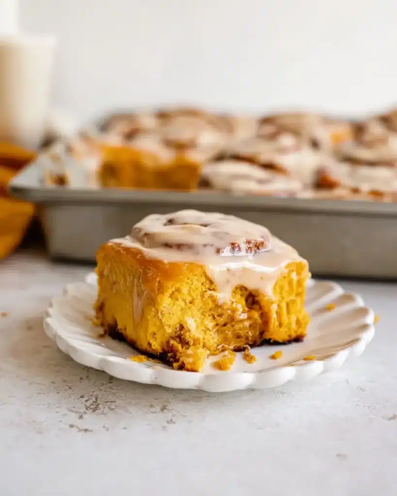 Pumpkin sweet roll with gooey maple coffee icing and bite taken
