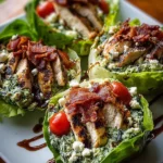 Pesto chicken lettuce wraps topped with feta, cherry tomatoes, and crispy bacon.