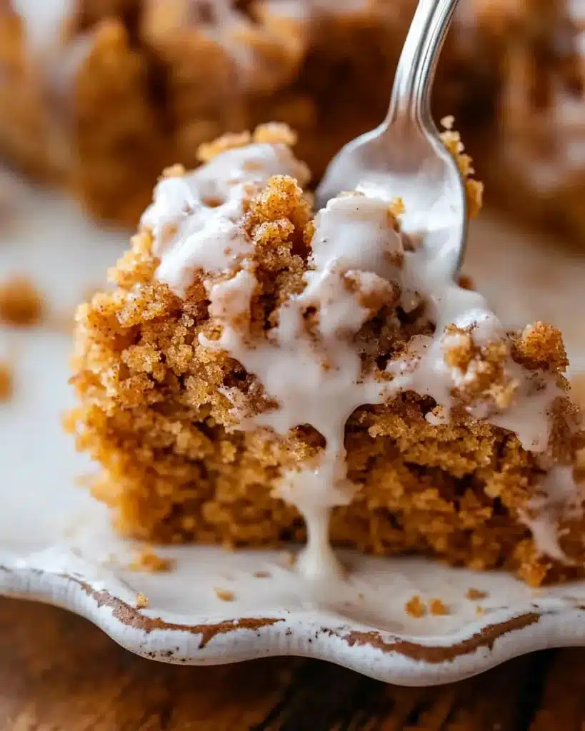 Fork slicing into glazed pumpkin coffee crumb cake
