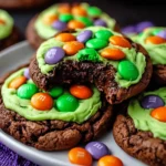Halloween chocolate cookies with green frosting and orange, green, purple M&M’s