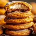 Chewy pumpkin cheesecake cookies stacked, showing creamy center.