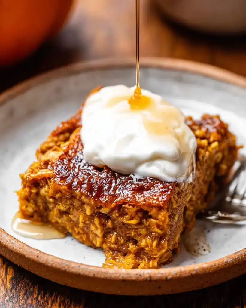 Pumpkin baked oatmeal slice topped with yogurt and honey drizzle