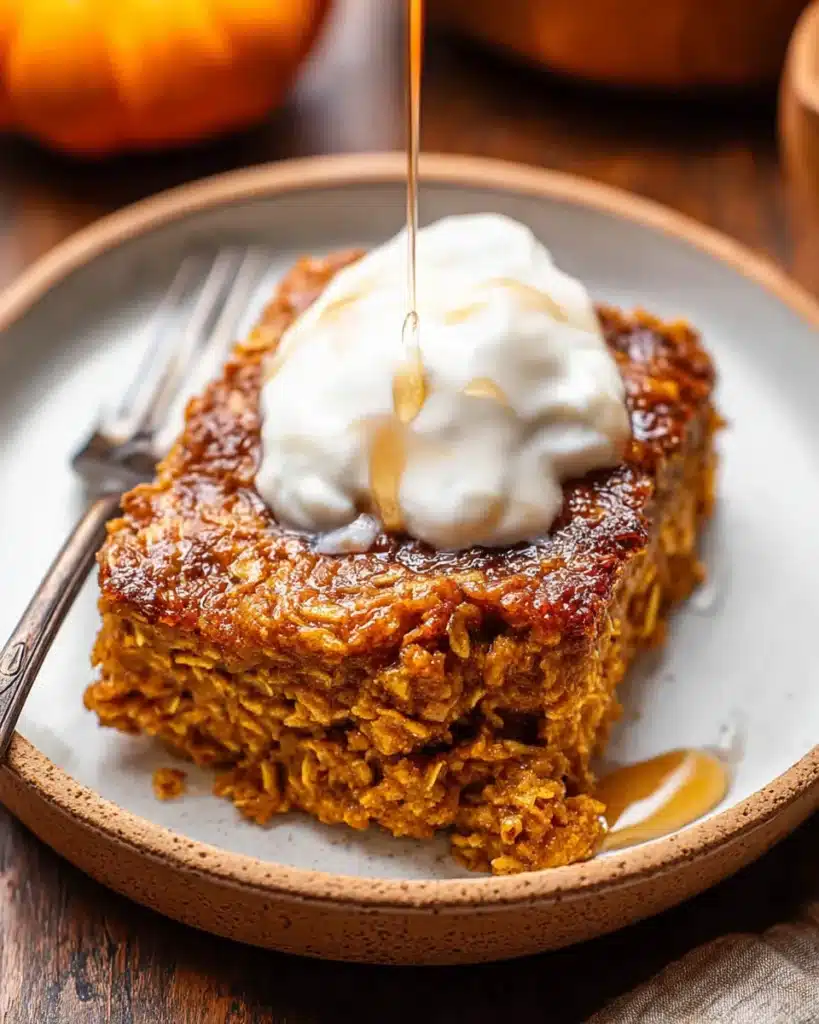 Slice of pumpkin baked oatmeal with yogurt and maple syrup drizzle