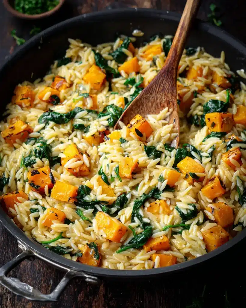 Skillet of creamy orzo with spinach and golden roasted butternut squash