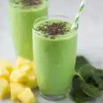 Green smoothie with spinach, pineapple, banana, and chia seeds in a glass